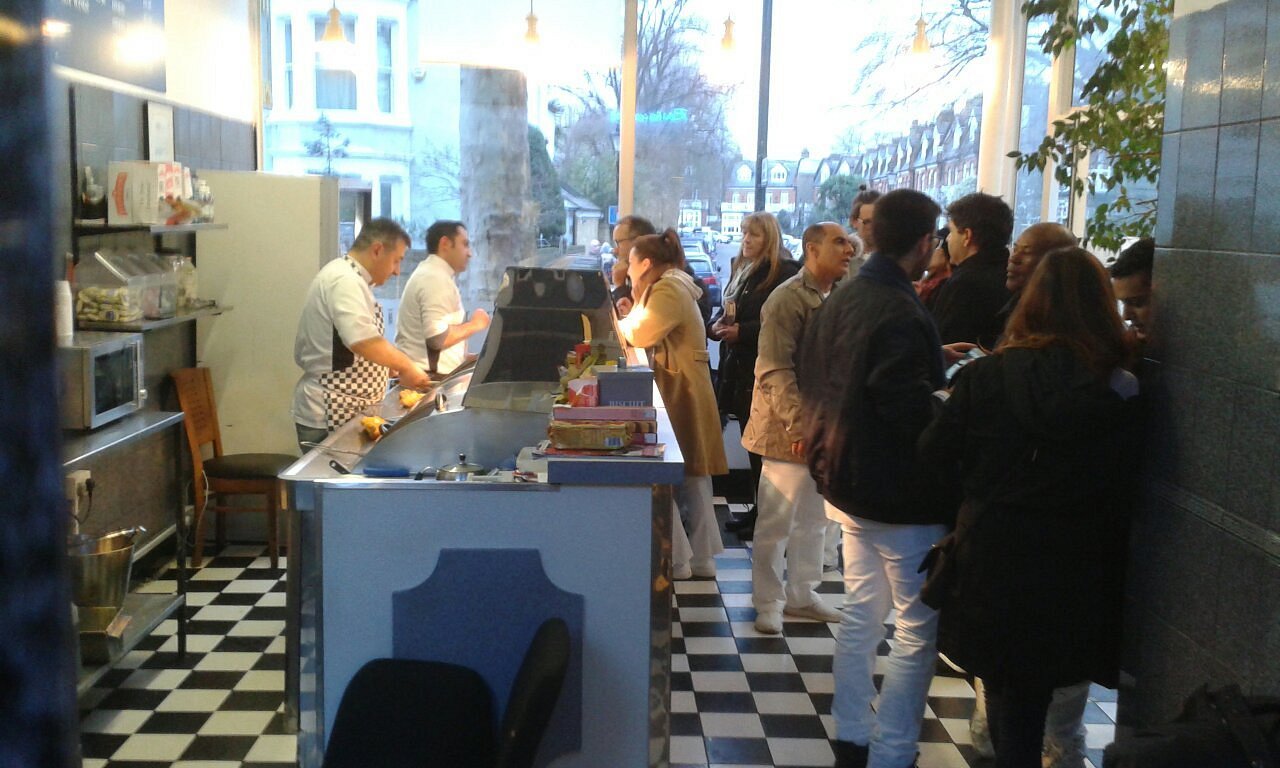 Customers queueing at the counter as staff fry to order