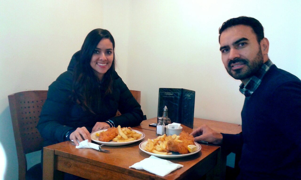 Two diners at a table with plates of fish and chips